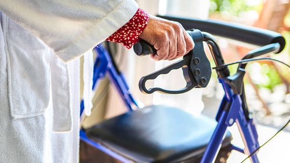 A senior woman in a bathrobe holds on to a walker.  © picture alliance/Zoonar Photo: Robert Kneschke