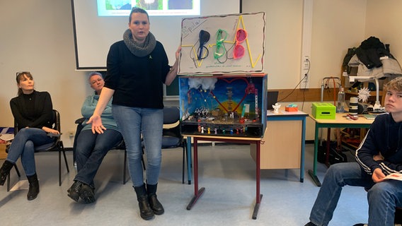 Verena Klose stands next to a box she made herself and tells a group her story.  © Corinna Below Photo: Corinna Below