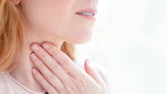 A woman puts her hand to her neck.  © IMAGO / Science Photo Library Photo: IMAGO / Science Photo Library