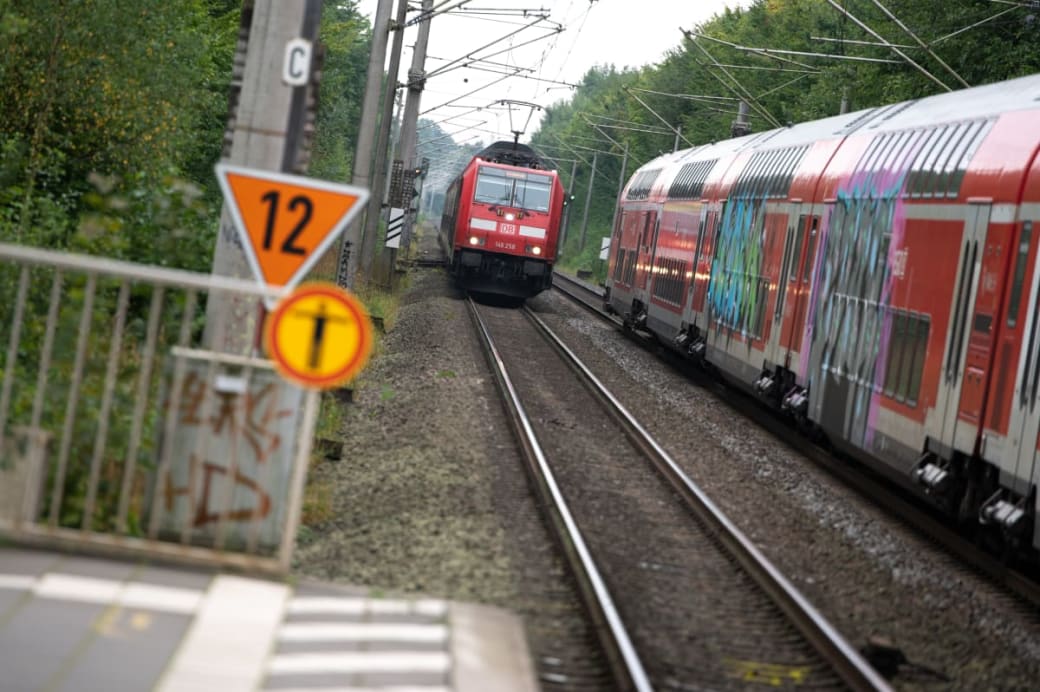 Two Deutsche Bahn (DB) regional trains meet in front of a train station.  Photo: Jonas Walzberg/dpa