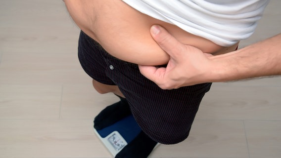 A man covers his stomach with his hands.  © Fotoalia Photo: yahyaikiz