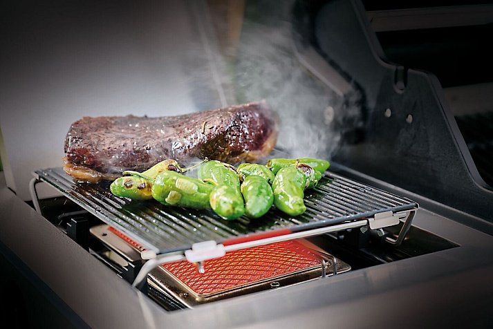 The blazing glass is placed over the infrared zone of the gas grill. It can withstand high temperatures, ensuring rich roasted aromas and a beautiful branding, for example with pimentos. The juice from fatty or heavily marinated meat does not drip into the infrared burner, so no flames can develop. - © Grillfürst/Grillfürst/dpa