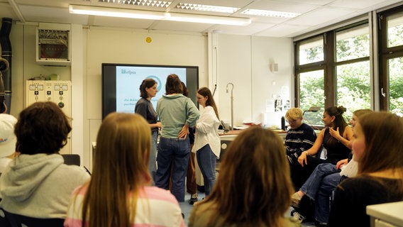 Four women discuss things in front of a group of schoolchildren. © NDR Photo: Lisa Pandelaki