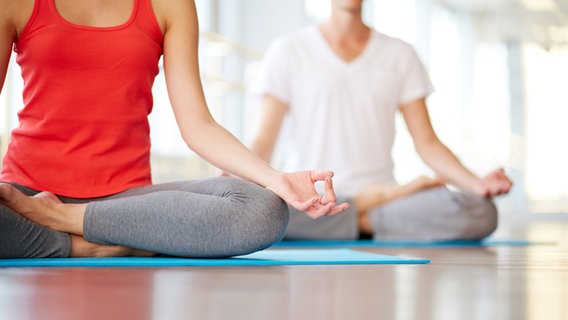 Two people sitting on mats in yoga pose. © colourbox Photo: Pressmaster