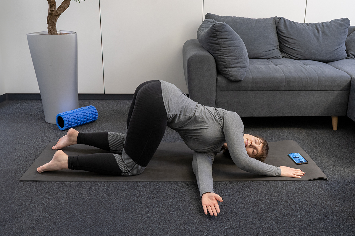 A woman does stretching exercises on the floor.