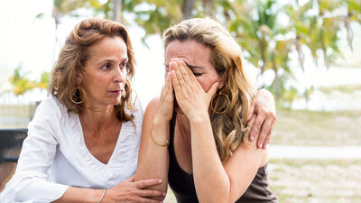 A woman comforts another woman