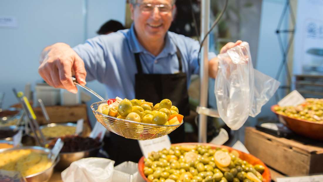 Nicolas Magurno fills a bag with olives at the “Slow Food” fair in Stuttgart (Baden-Württemberg) on ​​April 9, 2015. 