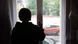 Brandenburg, Potsdam: A young girl looks out of a window.