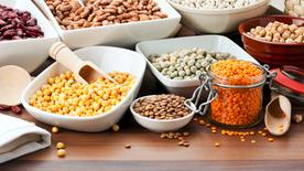 Dried lentils, chickpeas and beans are arranged next to each other in bowls.